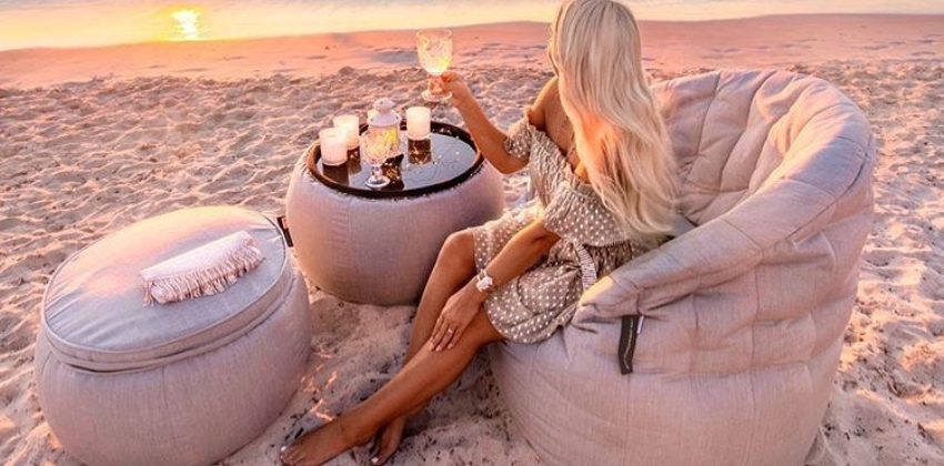 lady sitting on an Ambient lounge butterfly sofa set on a beach